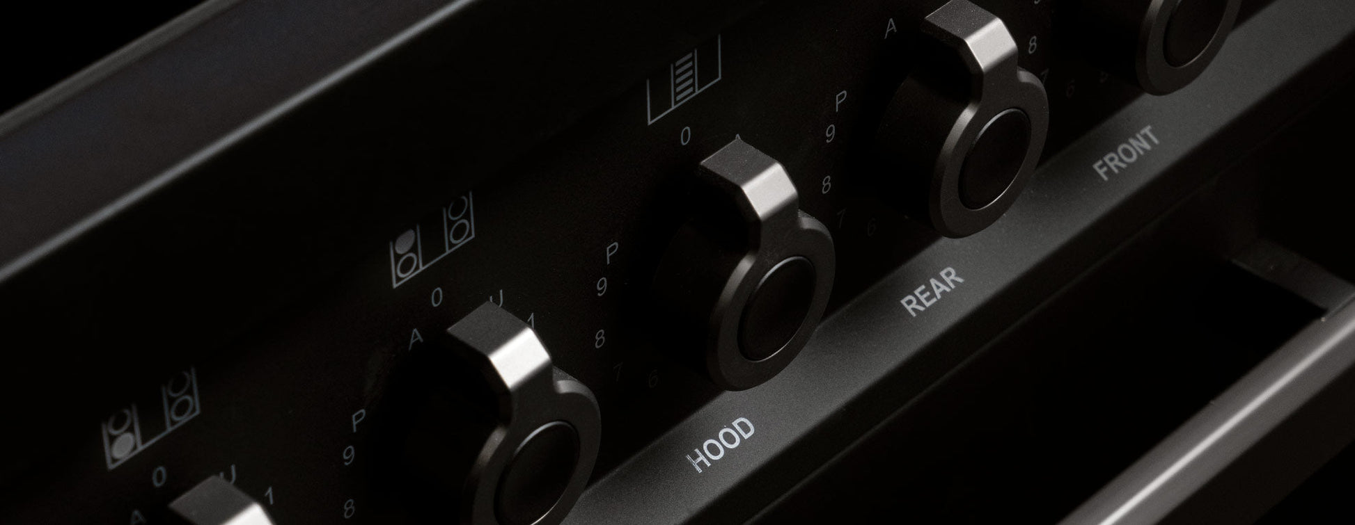 Close-up of black metal control knobs on Air-Tec 90 cm fornuis stove for managing hood, rear, and front zones.