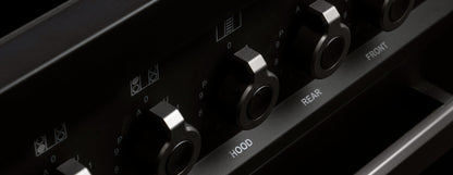 Close-up of black metal control knobs on Air-Tec 90 cm fornuis stove for managing hood, rear, and front zones.