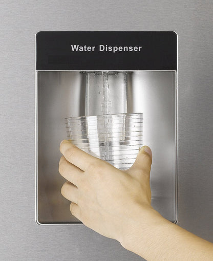 Hand vult glas met water uit waterdispenser van EDY EDHC8088 koel-vriescombinatie in inox look