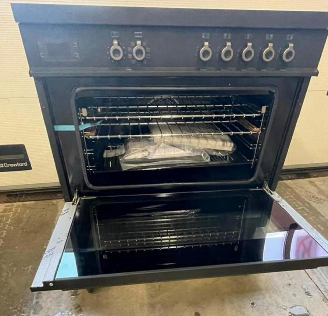 open zwart Air-Tec 90 cm fornuis met inductiekookplaat en oven met metalen knoppen